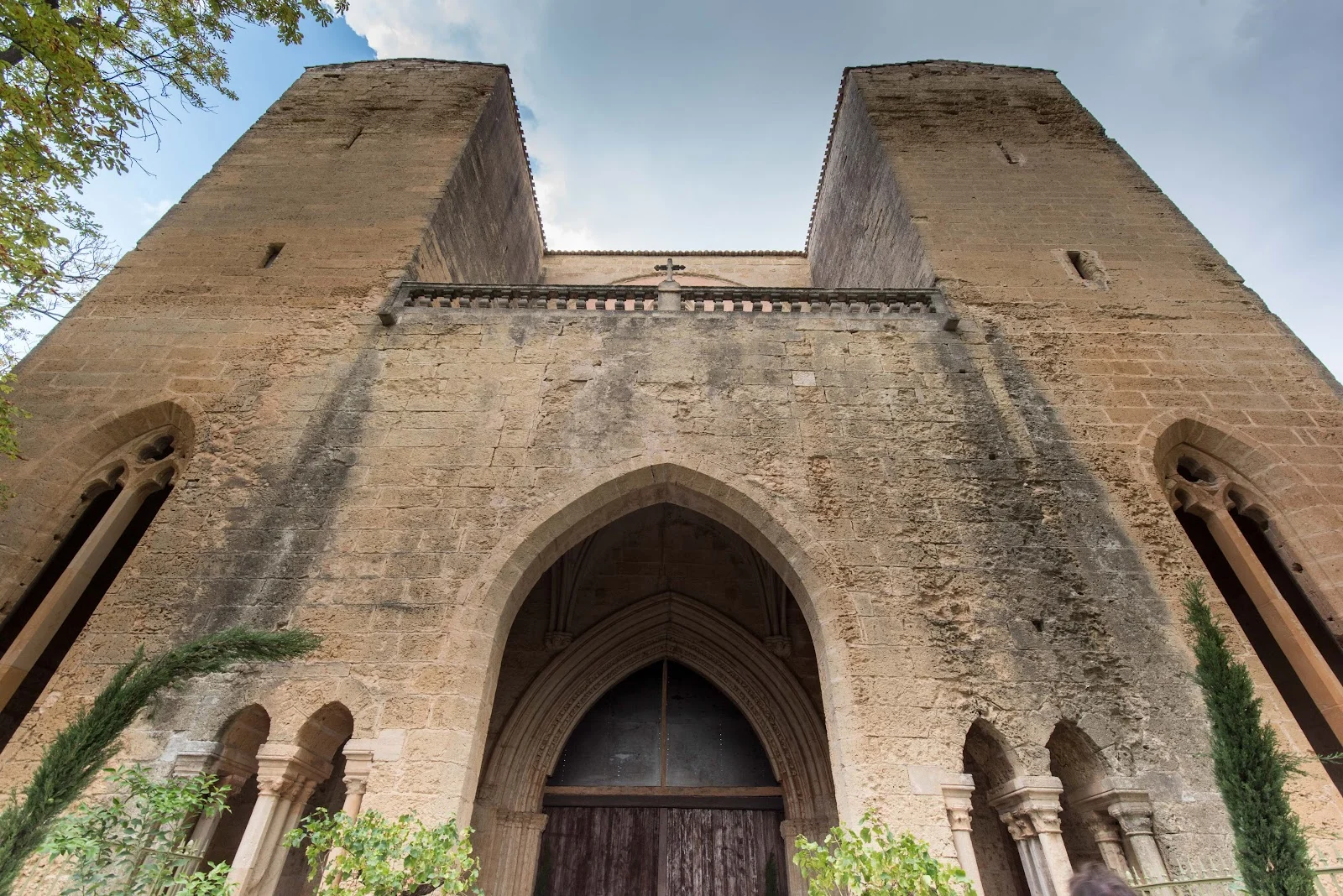 Façade gothique imposante de l'Abbaye de Valmagne avec portail en arc brisé et deux tours, entrée majestueuse pour mariage Hérault