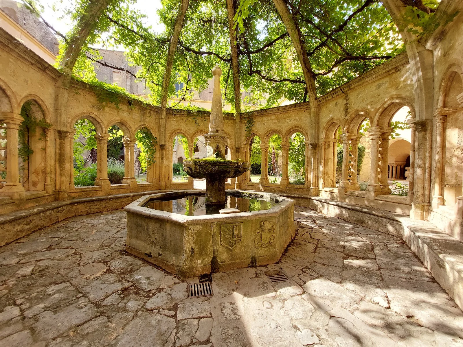 Fontaine médiévale octogonale dans le cloître de l'Abbaye de Valmagne, cadre romantique pour mariage dans l'Hérault