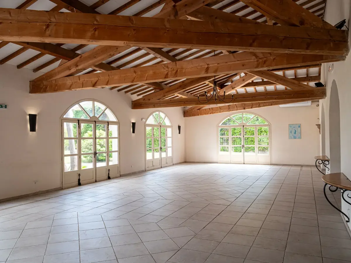 Grande salle lumineuse poutres apparentes baies vitrées jardin verdoyant Bergerie de la Vernède Nissan-lez-Enserune mariage Hérault Occitanie