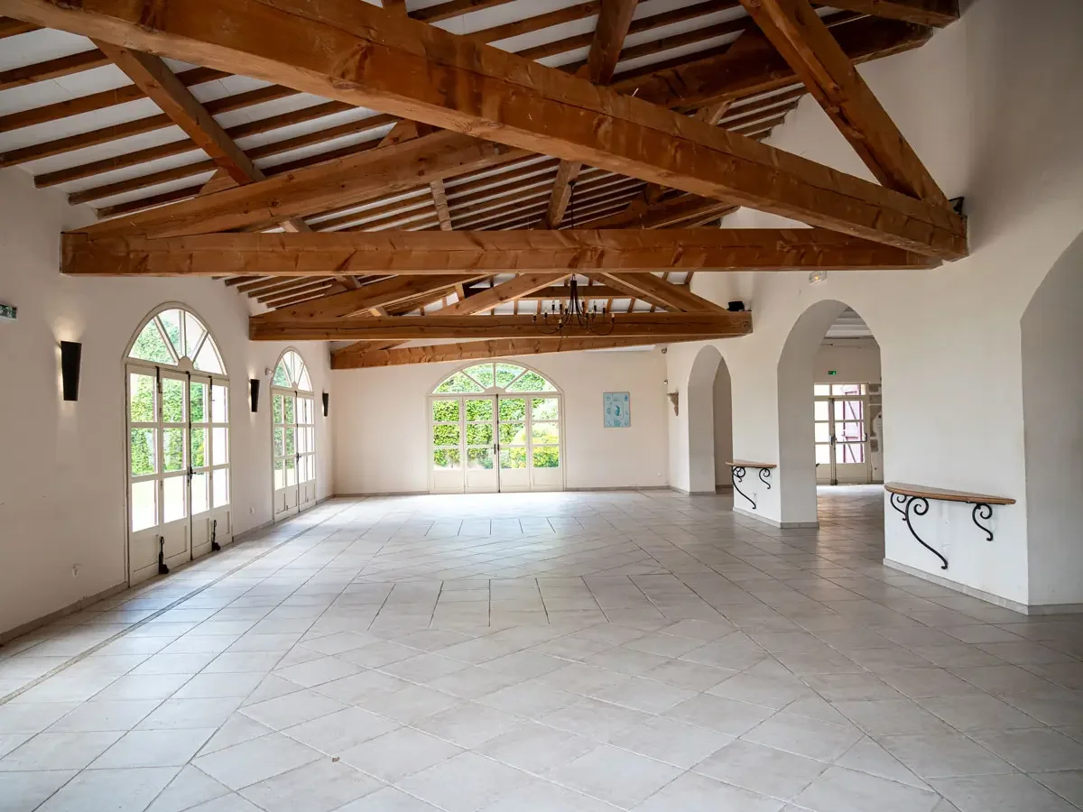 Grande salle lumineuse poutres apparentes baies vitrées jardin Bergerie de la Vernède Nissan-lez-Enserune mariage Hérault Occitanie