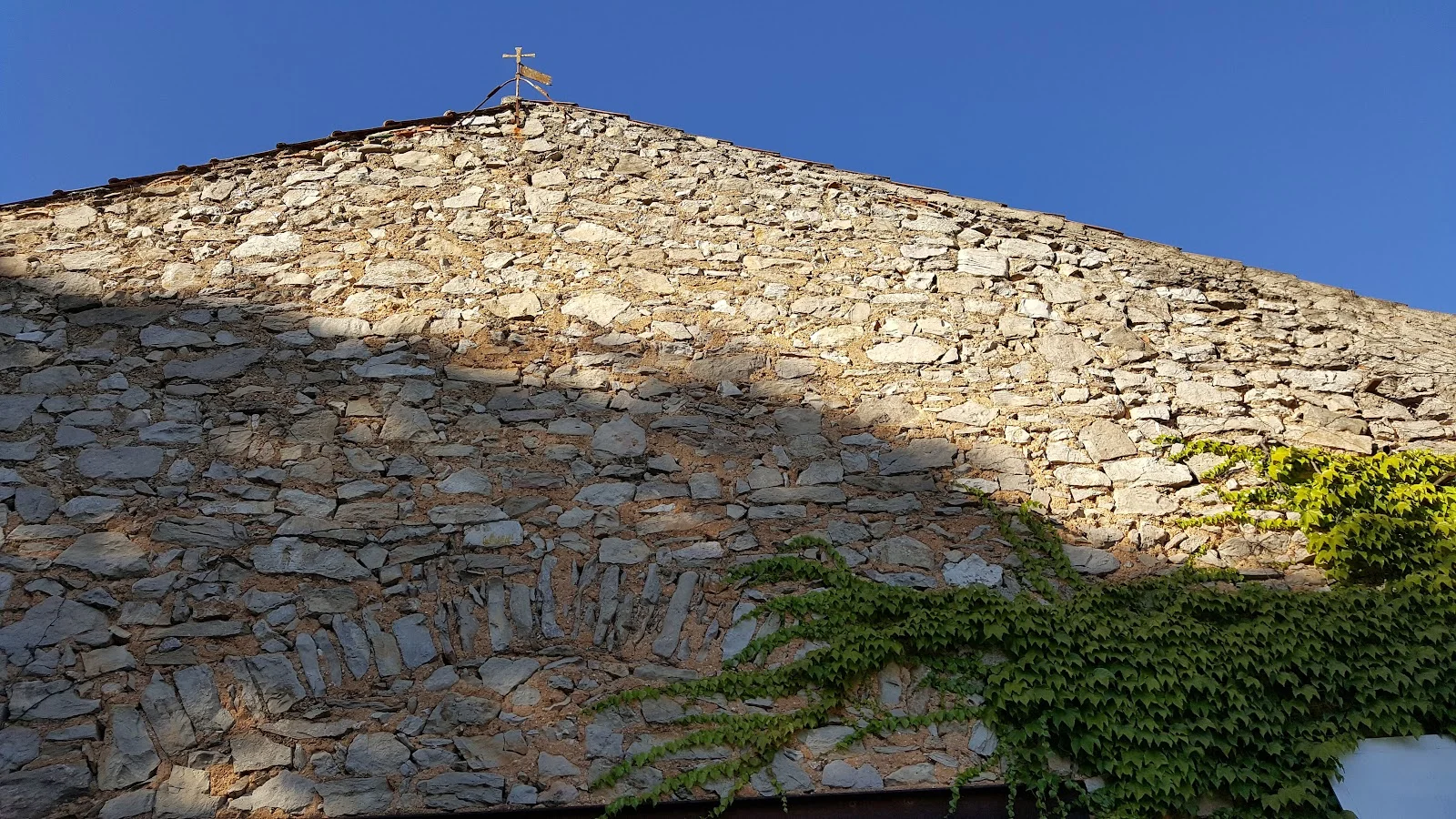 Détail du mur en pierre sèche et girouette dorée du Château Bas d'Aumelas, domaine viticole et de mariage en Hérault