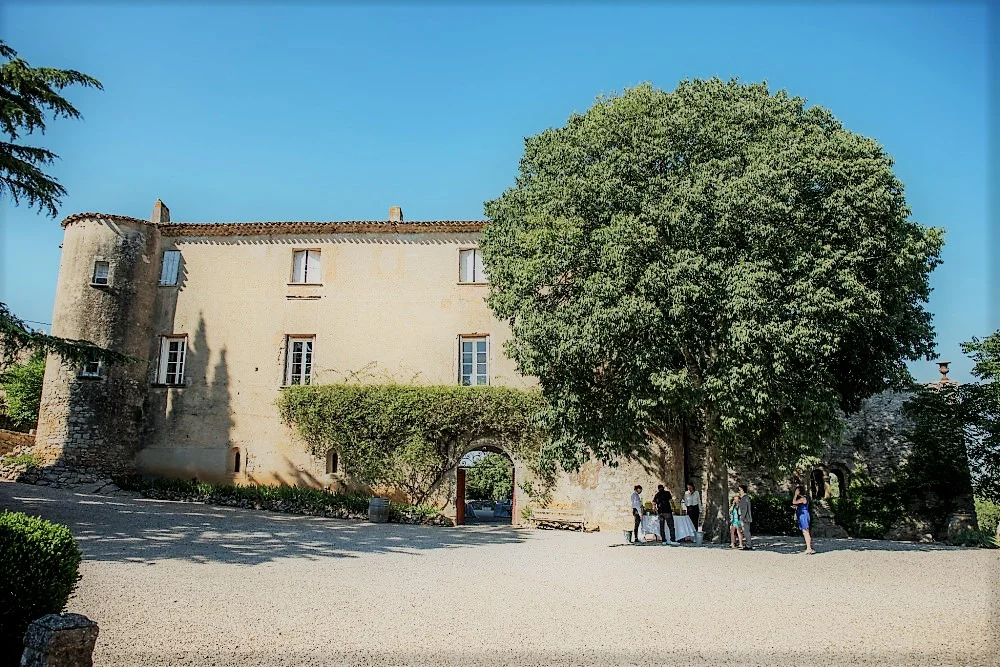 Vue d'ensemble du Château Bas d'Aumelas avec cour gravillonnée et invités lors d'un mariage en Hérault