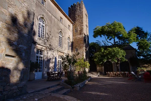 Cour intérieure du Château d'Agel avec tables de réception en extérieur et tour médiévale, mariage en Hérault