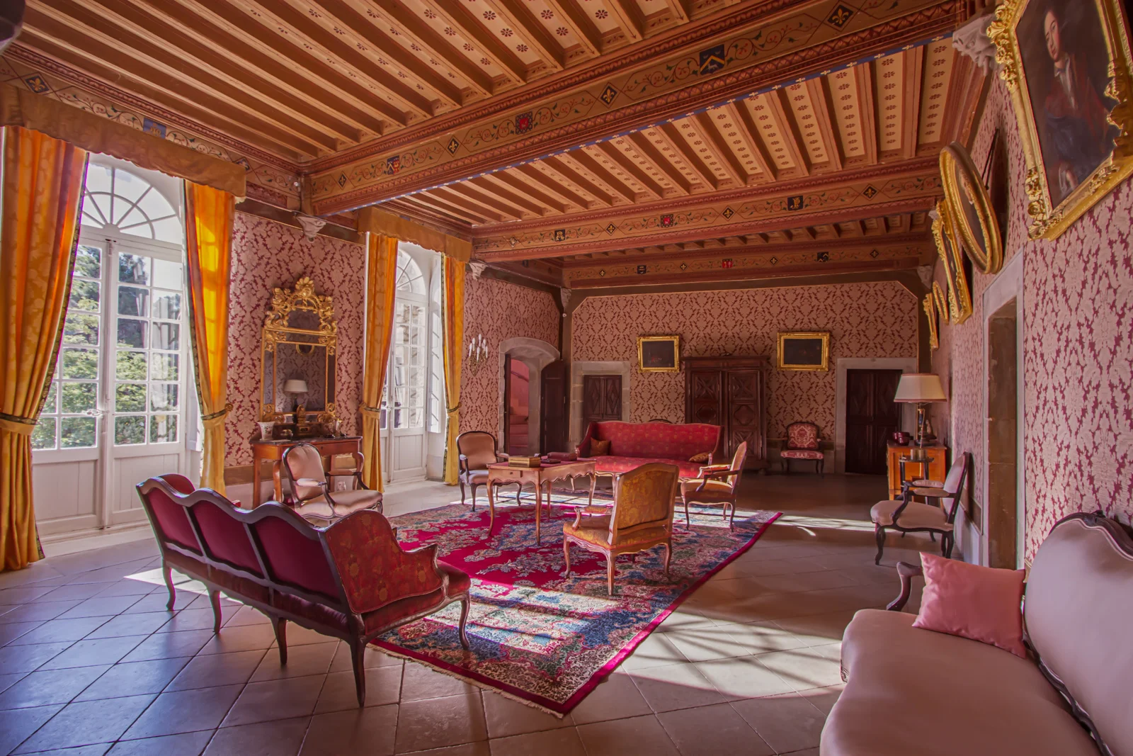 Grand salon de réception du Château d'Agel avec plafond peint, mobilier Louis XV et décor rouge et or pour mariage Hérault