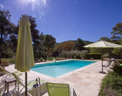 Piscine extérieure du Château d'Agel entourée de parasols et chaises longues, domaine de mariage en Hérault