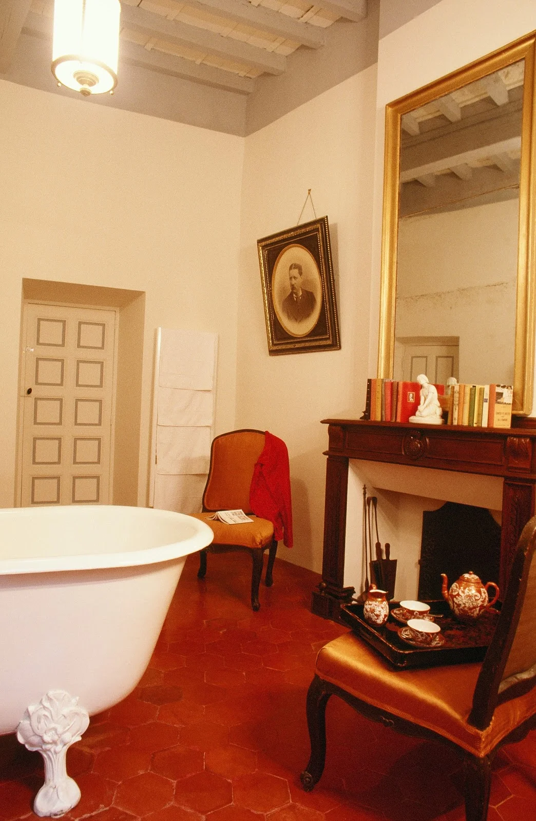 Salle de bains avec baignoire sur pieds et cheminée du Château d'Agel, hébergement de charme pour mariage en Hérault