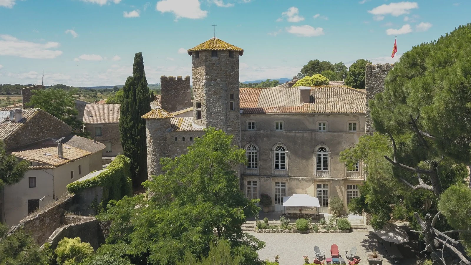 Vue aérienne de la façade principale du Château d'Agel et sa cour pavée, domaine de prestige pour mariage en Hérault