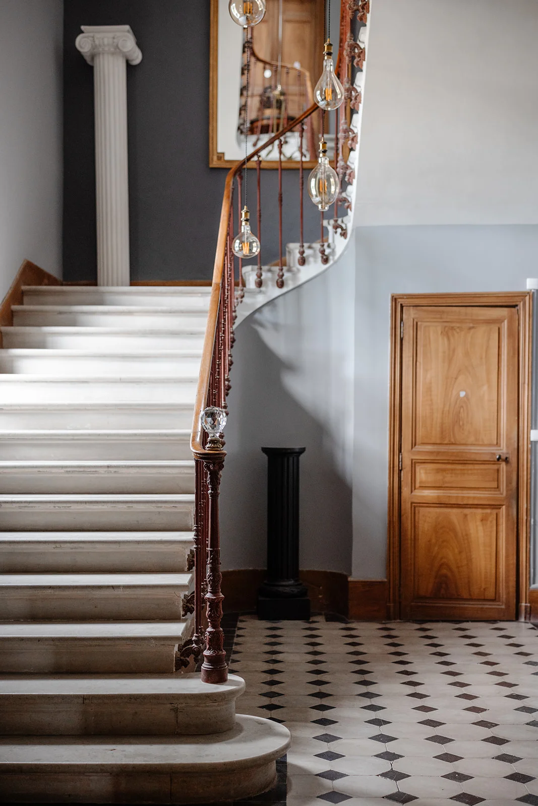 Escalier monumental en pierre du Château de Bayssan avec rampe fer forgé et carrelage damier, mariage Hérault
