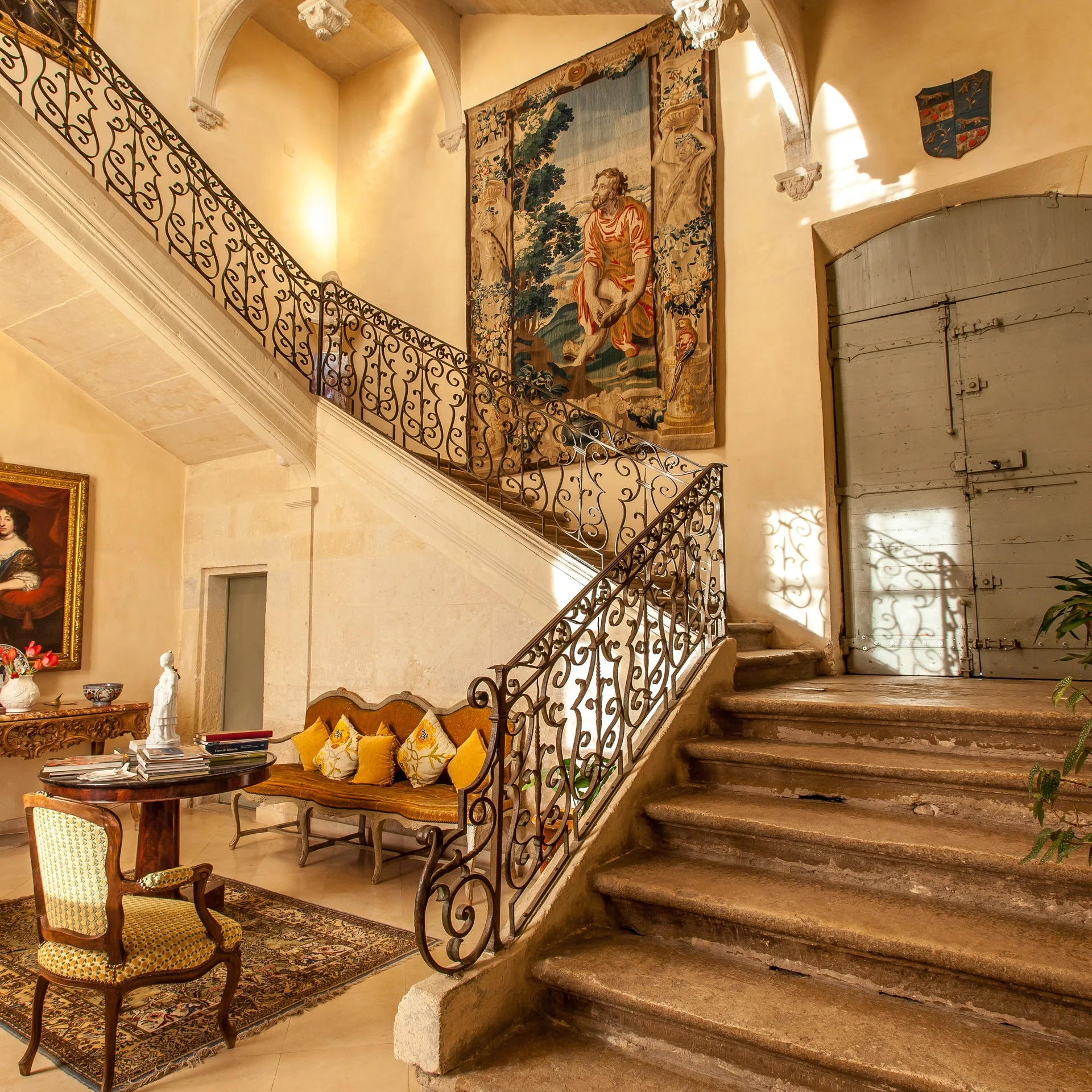 Escalier monumental intérieur du Château de Flaugergues avec rampe en fer forgé et tapisserie ancienne, Hérault