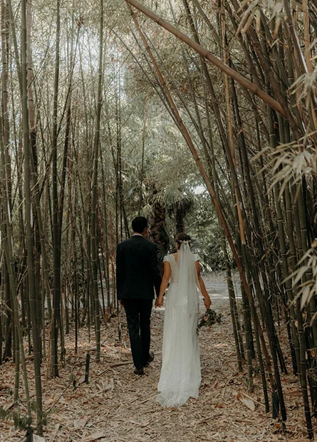 Couple de mariés se promenant dans l'allée de bambous du Château de Flaugergues en Hérault