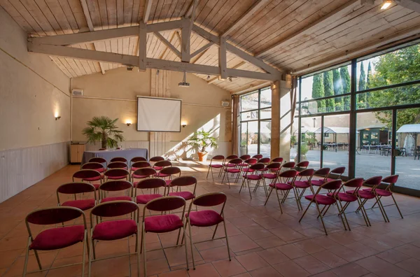 Salle de réception du Château de Flaugergues avec chaises rouges et baie vitrée, Hérault