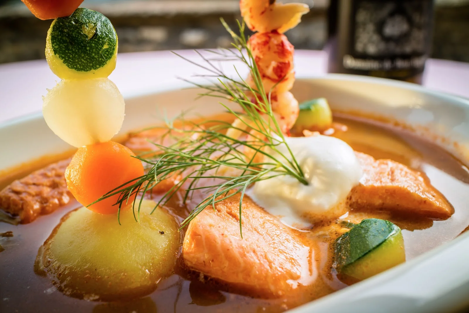 Plat gastronomique du Château de Lunas : saumon, légumes et brochette de crustacés, restaurant Hérault