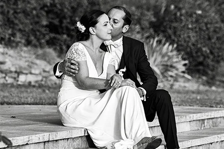 Portrait noir et blanc couple de mariés assis sur un muret au Château de Malmont Hérault