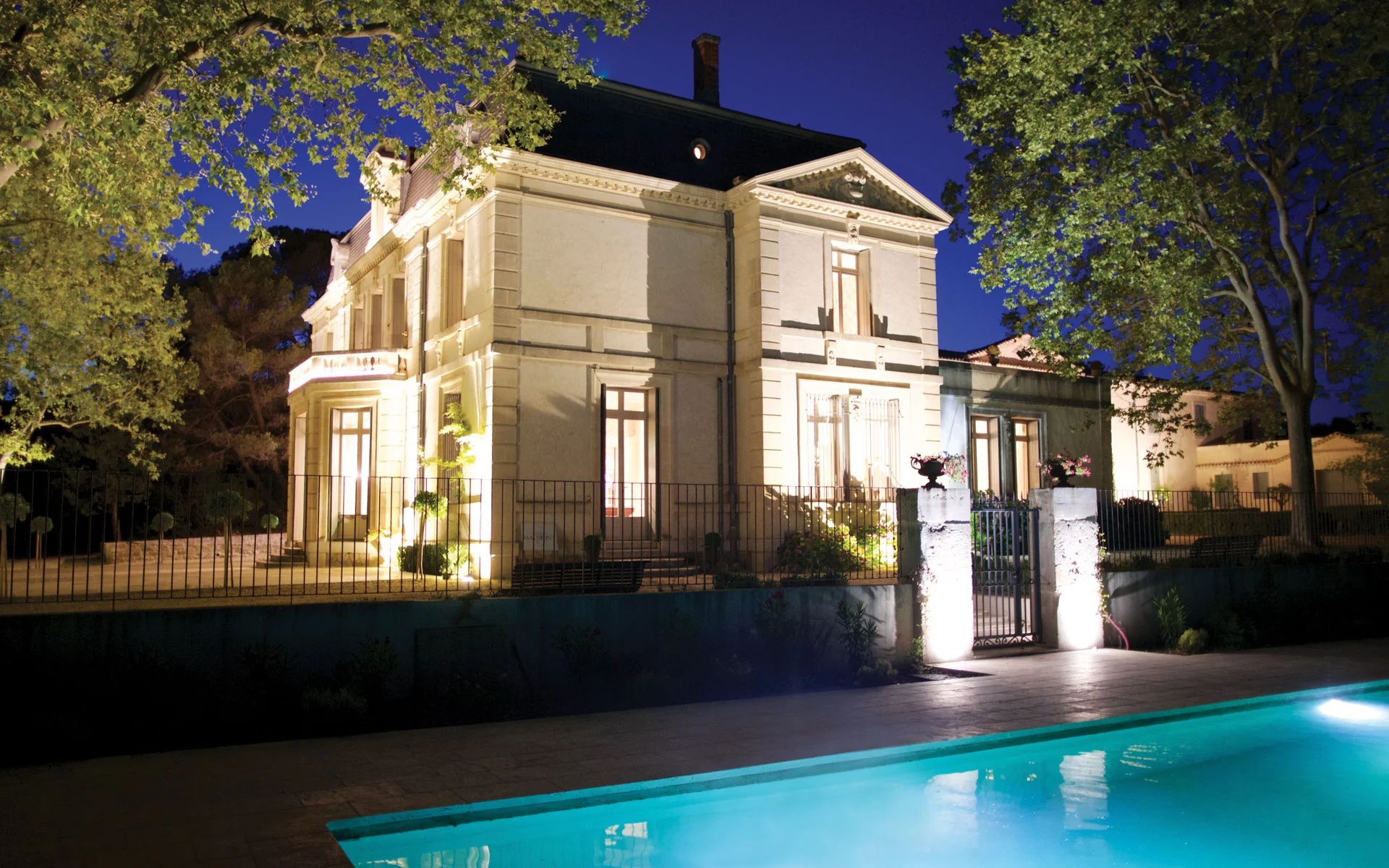 Château de Malmont illuminé la nuit avec piscine au premier plan - domaine mariage Hérault