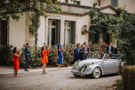 Invités de mariage devant la façade du Château de Malmont avec coccinelle VW - domaine Hérault