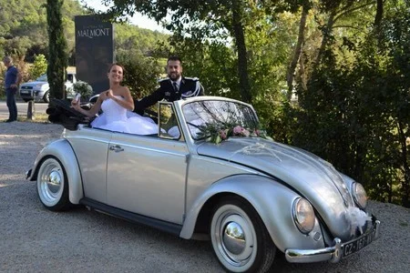 Couple de mariés dans une coccinelle VW cabriolet vintage au Château de Malmont Hérault