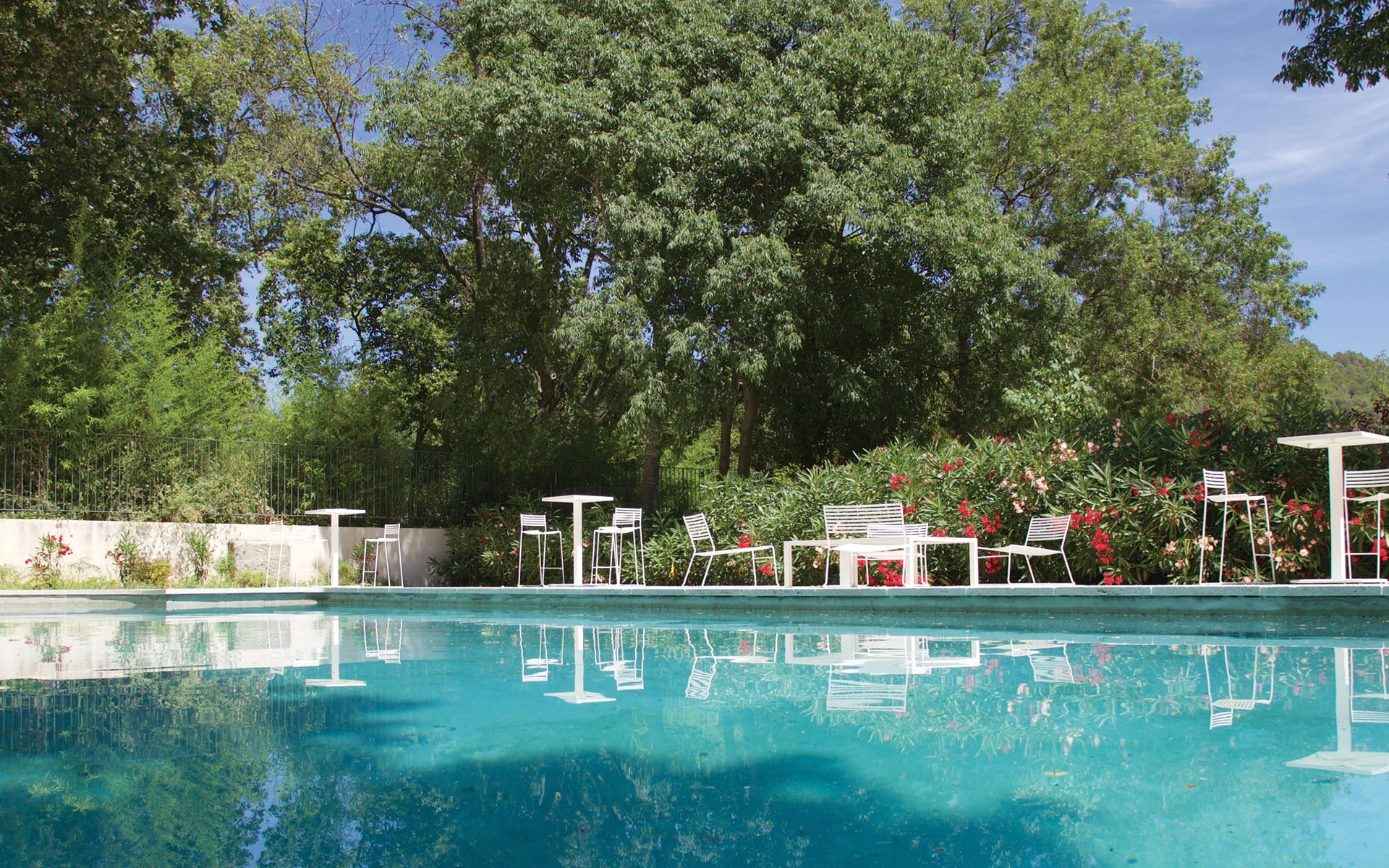 Piscine extérieure turquoise avec jardin fleuri au Château de Malmont - domaine mariage Hérault