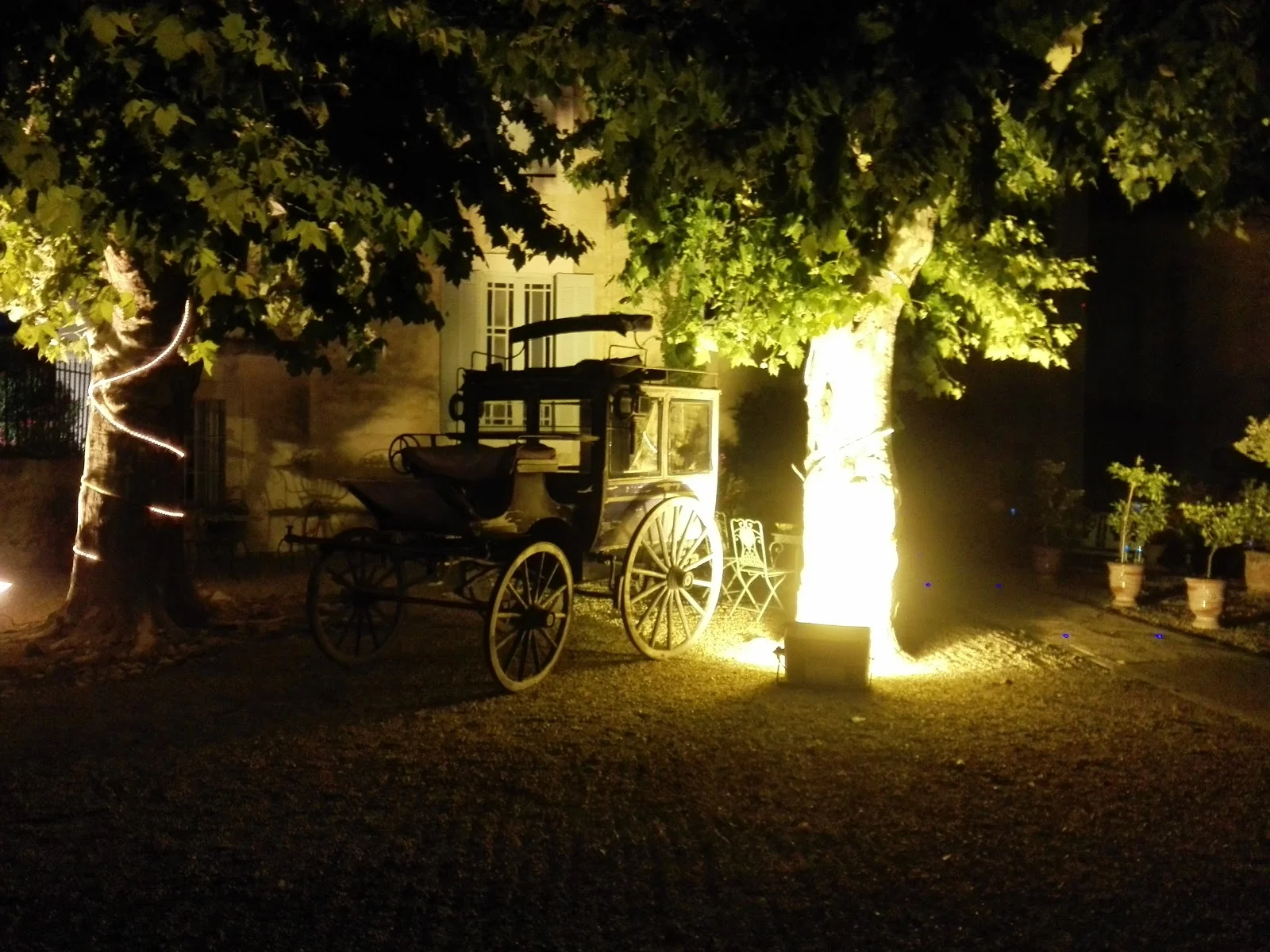 Calèche ancienne illuminée sous les platanes du Château de Pouget pour mariage romantique Hérault