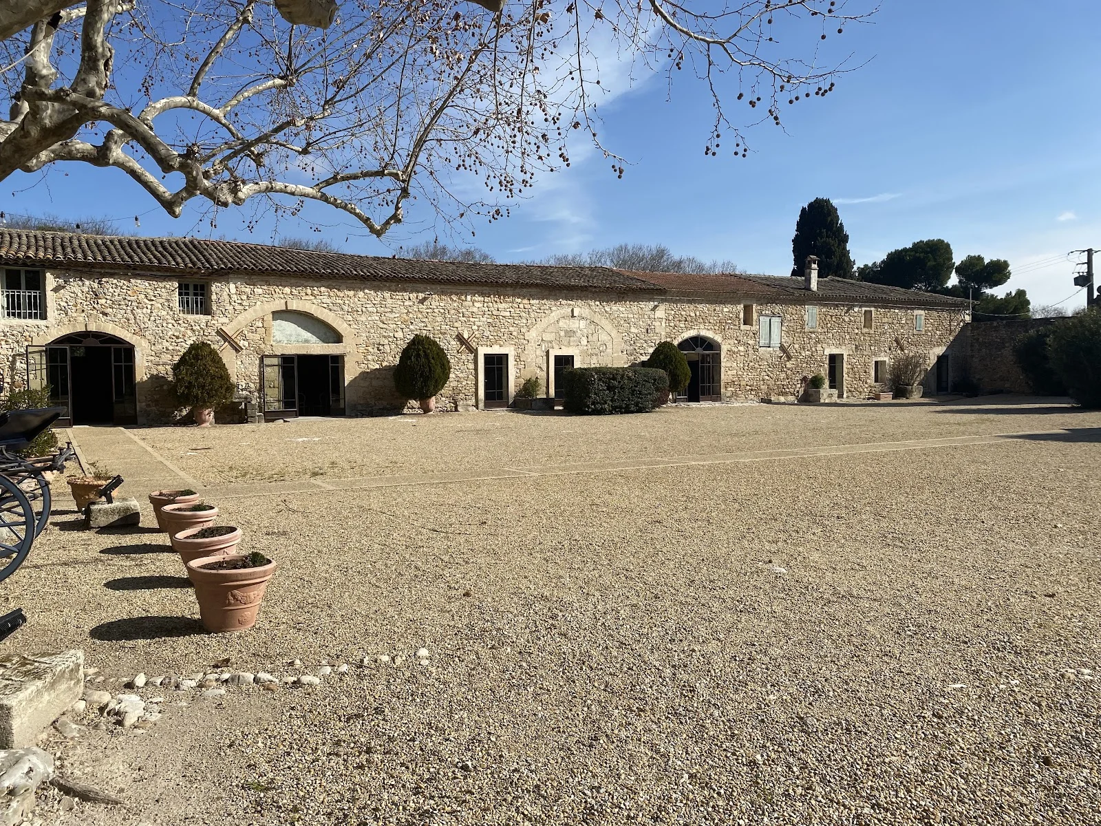 Cour intérieure du Château de Pouget avec dépendances en pierre et arches - mariage Hérault
