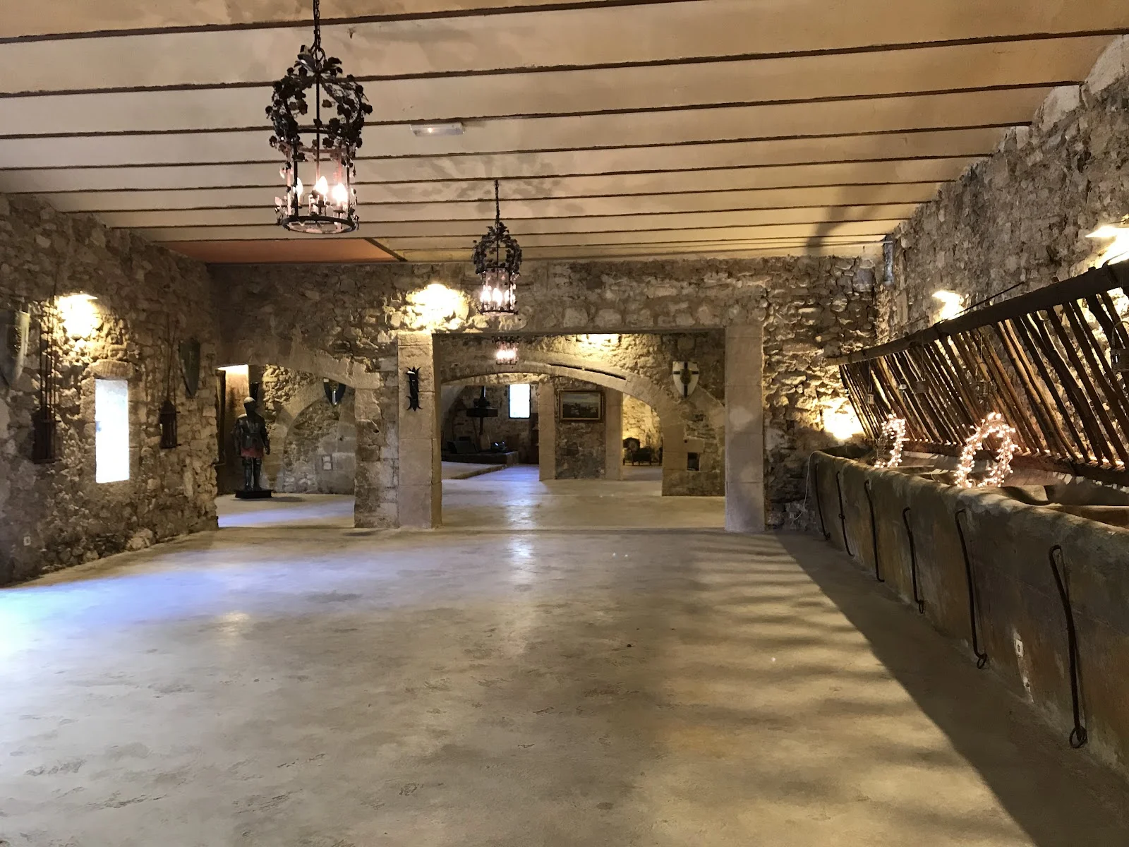 Salle voûtée en pierre du Château de Pouget avec lustres fer forgé pour mariage Hérault