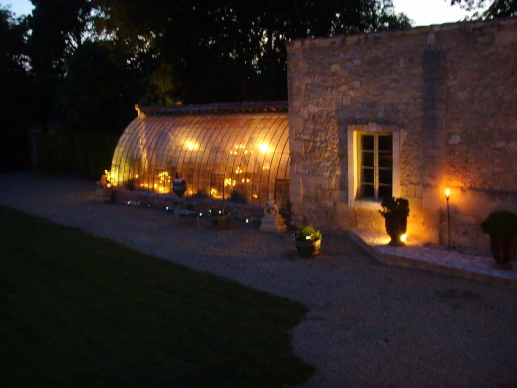 Serre du Château de Pouget illuminée la nuit pour un mariage féerique dans l'Hérault