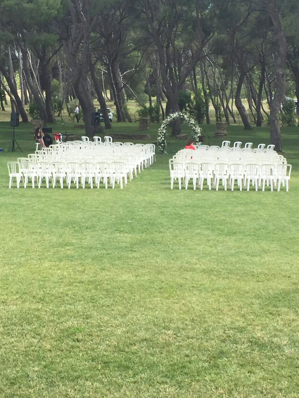Cérémonie laïque extérieure mariage Château de Sériège Hérault avec arche fleurie et chaises blanches dans la pinède
