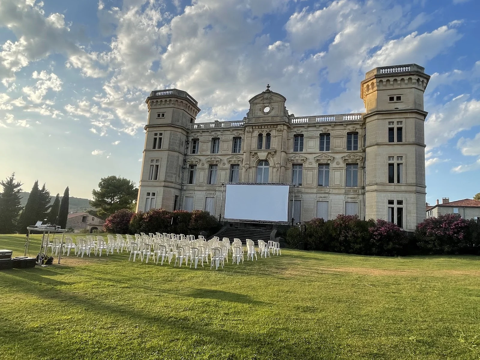 Château de Sériège Hérault cinéma plein air événement avec écran géant et chaises blanches sur pelouse