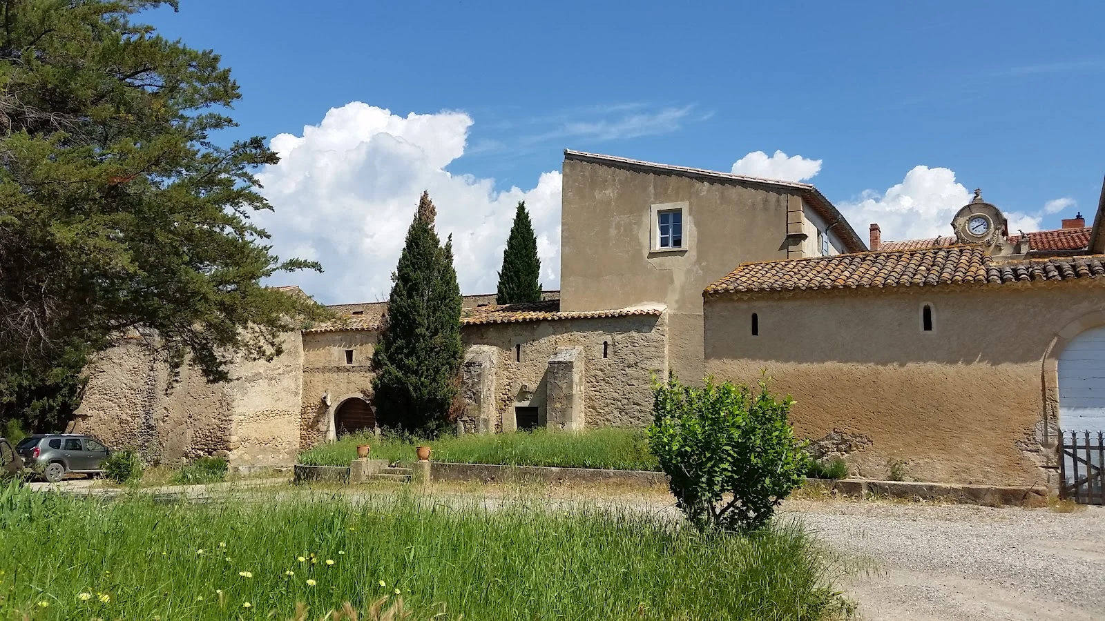 Dépendances anciennes en pierre du Château de Sériège Hérault avec cyprès et architecture provençale
