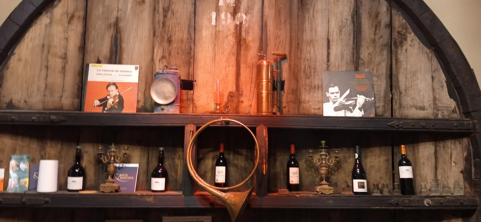 Décoration vintage Bach et Bacchus avec vinyles classiques et bouteilles de vin sur fût en bois au Domaine du Bosc