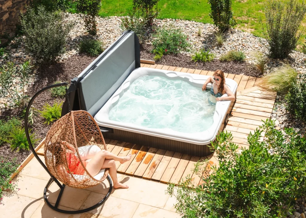 Jacuzzi extérieur sur terrasse bois avec jardin paysager au Château du Parc pour mariage dans l'Hérault