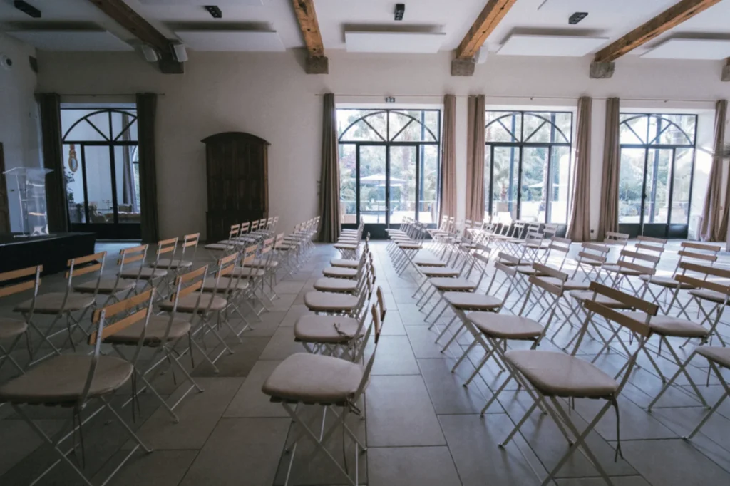 Salle cérémonie intérieure lumineuse Château Hermitage Combas Hérault chaises blanches coussins