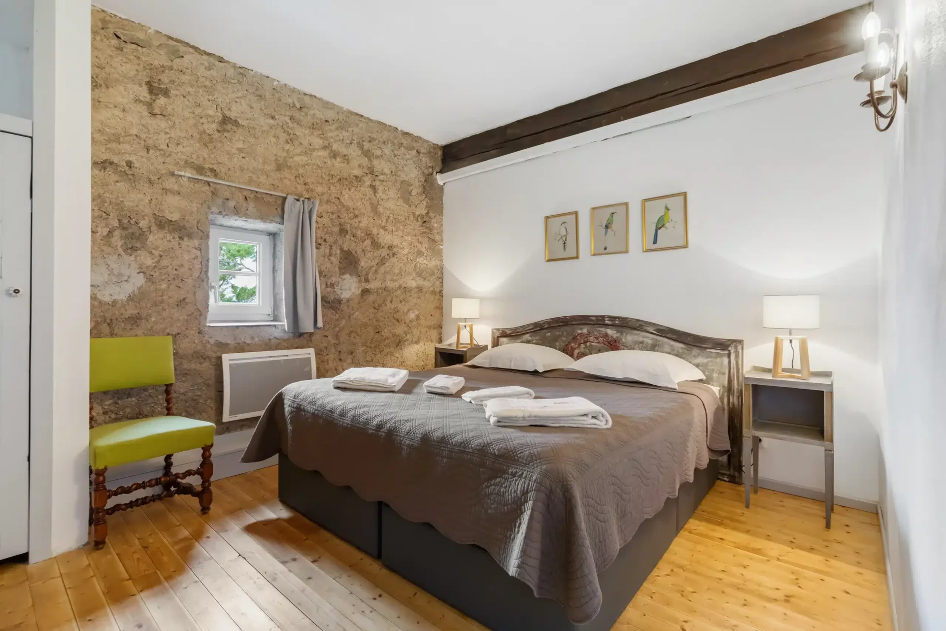 Chambre avec mur en pierre apparente au Château Hermitage de Combas, domaine de mariage dans l'Hérault