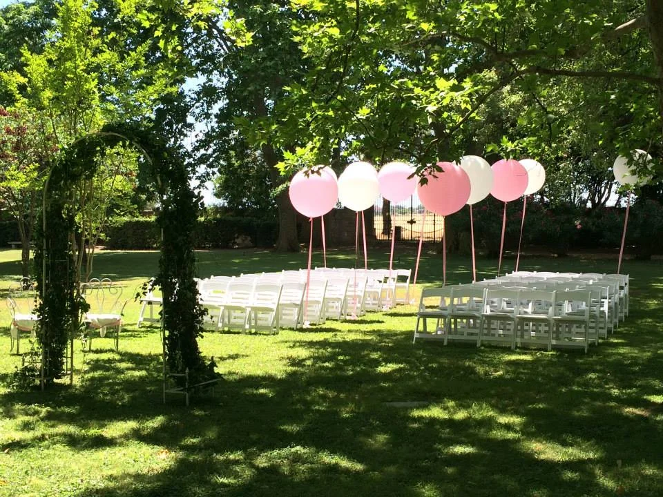 Cérémonie laïque mariage extérieure au Château La Banquière Hérault avec chaises blanches et ballons géants roses