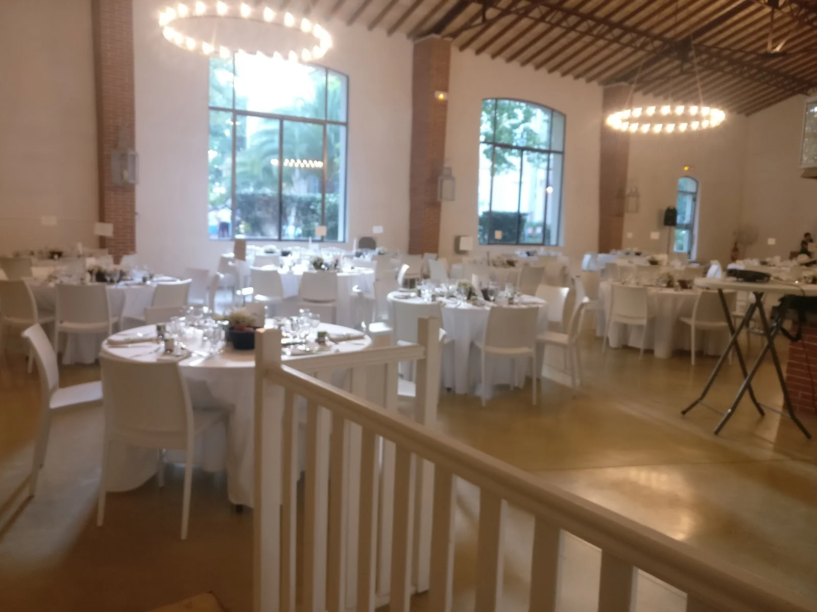 Salle de réception mariage au Château La Banquière Hérault avec tables rondes et lustres circulaires élégants