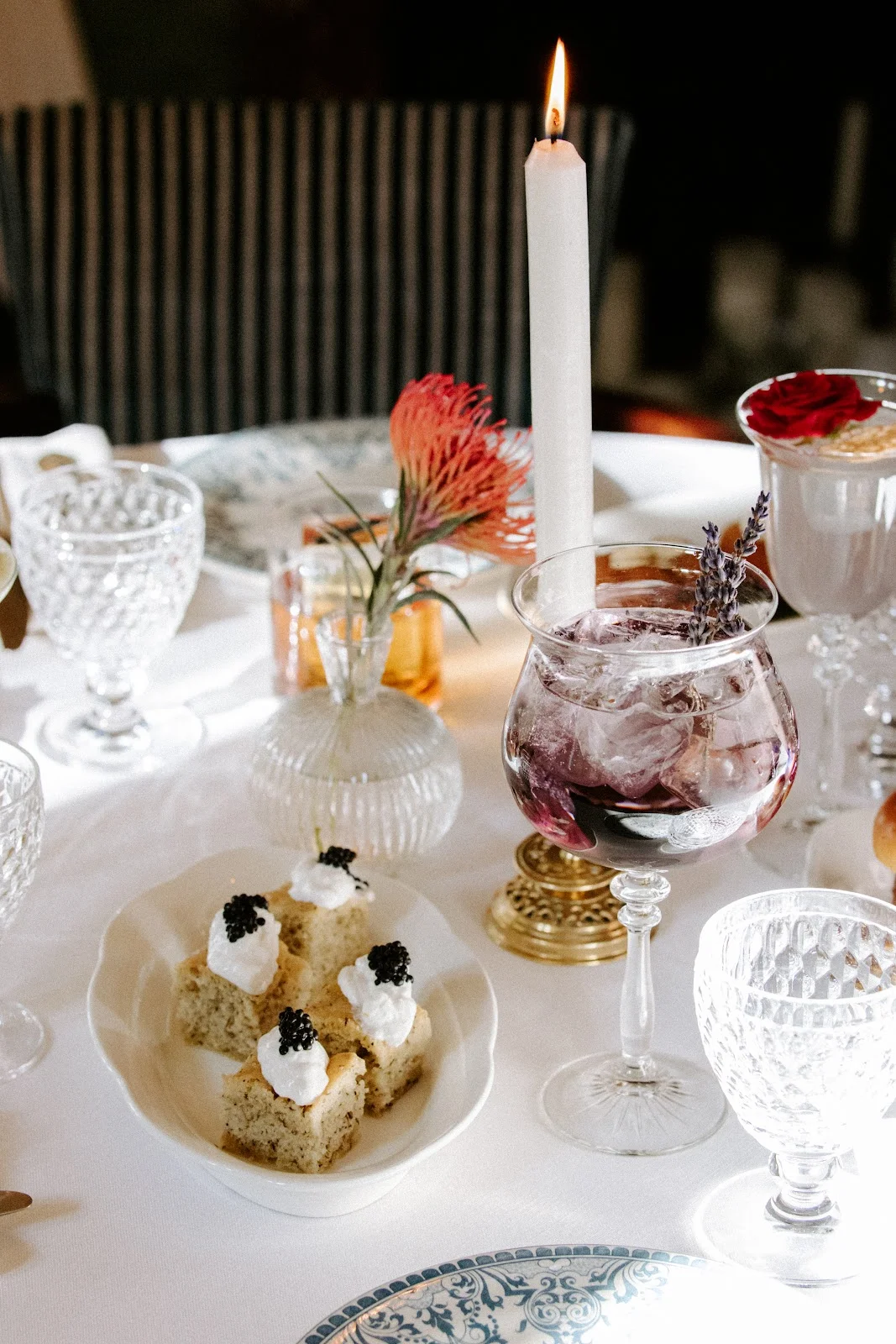 Mise en place de table au Château Paloma dans l'Hérault avec canapés au caviar, cocktail lavande et bougie pour mariage