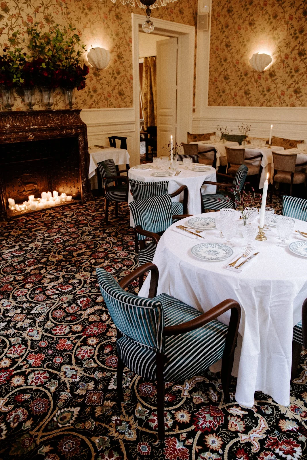 Salle de réception du Château Paloma dans l'Hérault avec cheminée, bougies et tables dressées pour un mariage