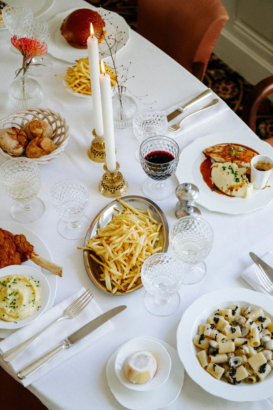 Table de dîner gastronomique dressée au Château Paloma dans l'Hérault avec frites, burger et pasta au caviar