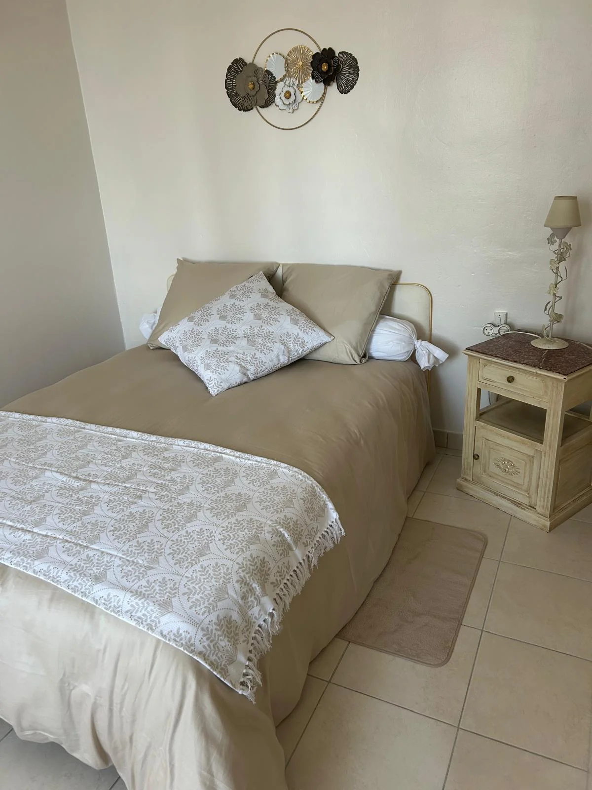Chambre élégante beige et dorée avec décoration florale murale au Château Périès, hébergement mariage Hérault