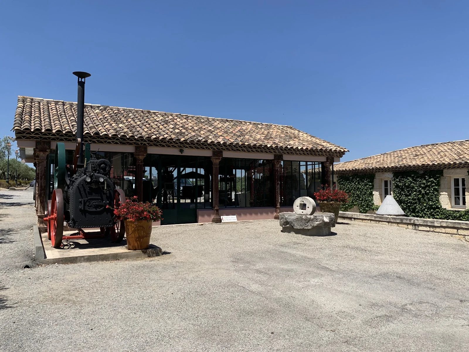 Espace réception du Château Puech-Haut avec machine à vapeur vintage et meule en pierre, lieu de mariage original en Hérault