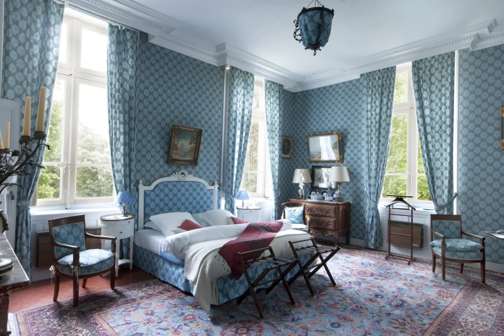 Chambre bleue lumineuse avec vue sur parc au Château Raissac Hérault, mobilier Empire et tapis persan pour mariage