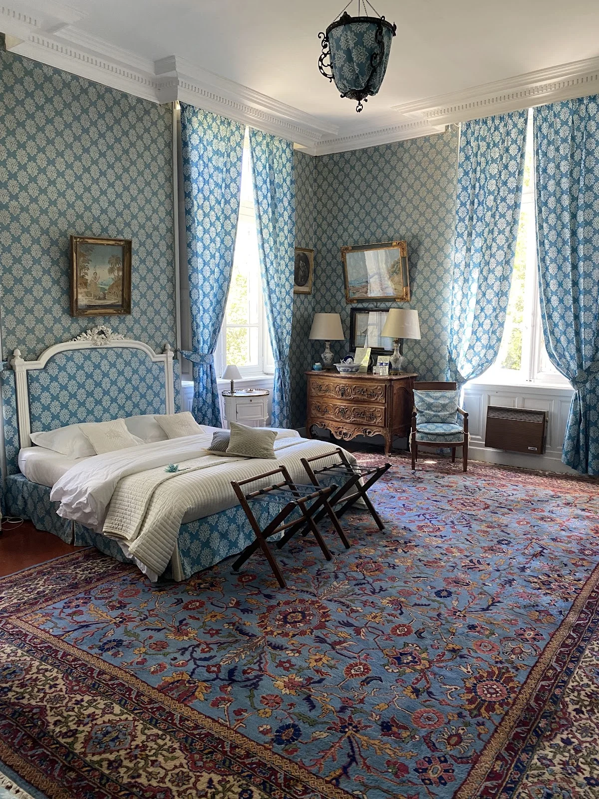 Chambre bleue de style Louis XVI au Château Raissac Hérault, tapis persan et mobilier ancien pour séjour mariage