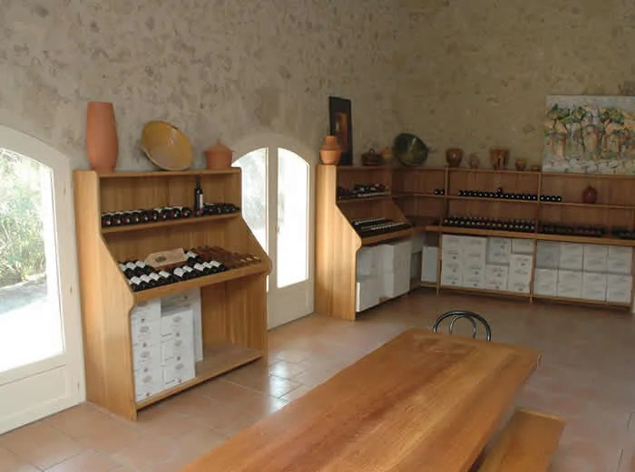 Cave de dégustation du Château Saint Martin de Graves avec étagères bois et bouteilles de vin, Hérault