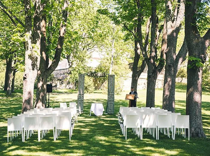 Cérémonie laïque extérieure sous les arbres avec chaises blanches au Château Saint Martin de Graves, mariage Hérault