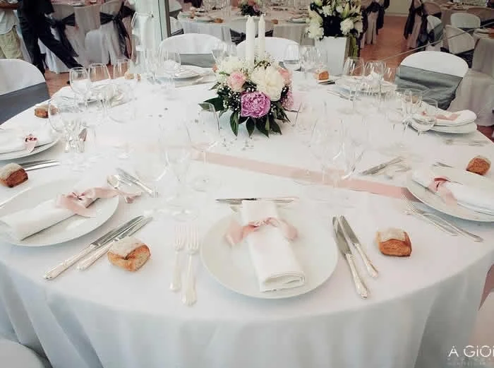 Table de mariage décorée avec pivoines roses, verres cristal et nappage blanc au Château Saint Martin de Graves Hérault