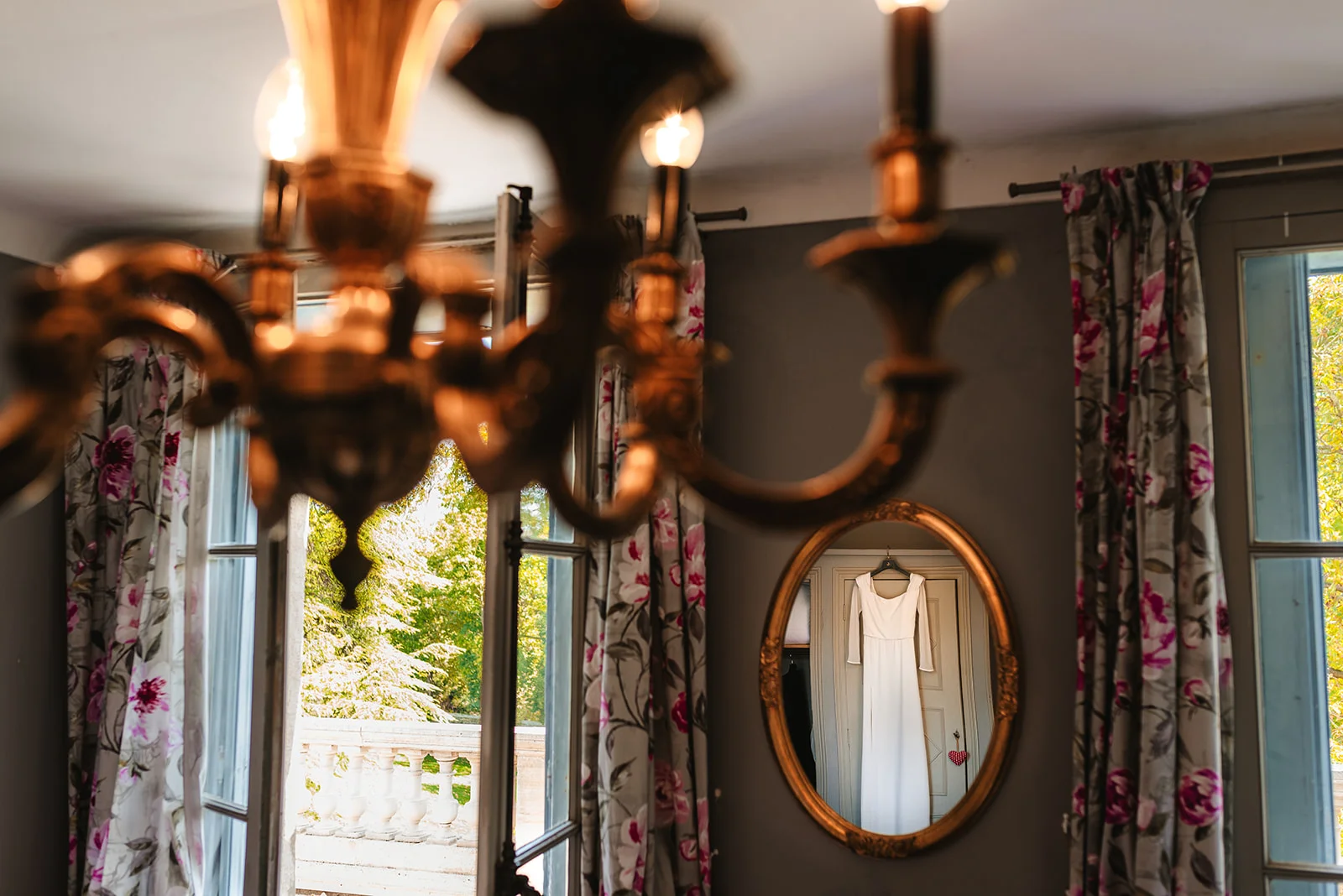 Robe de mariée reflétée dans miroir doré d'une chambre du Château Sainte Cécile Hérault