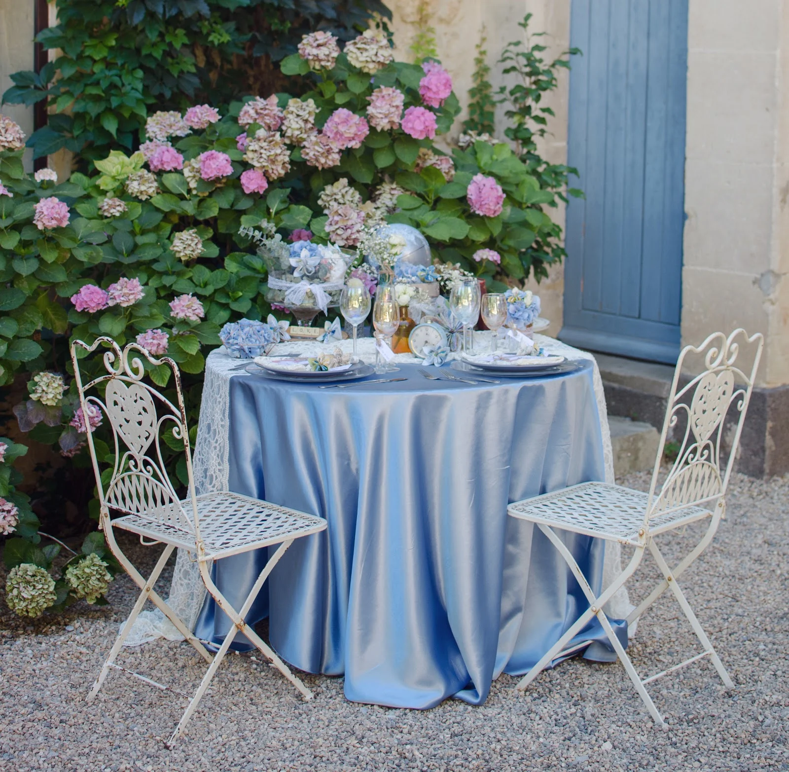 Table extérieure décorée avec nappe bleue et hortensias au Château Sainte Cécile pour mariage Hérault