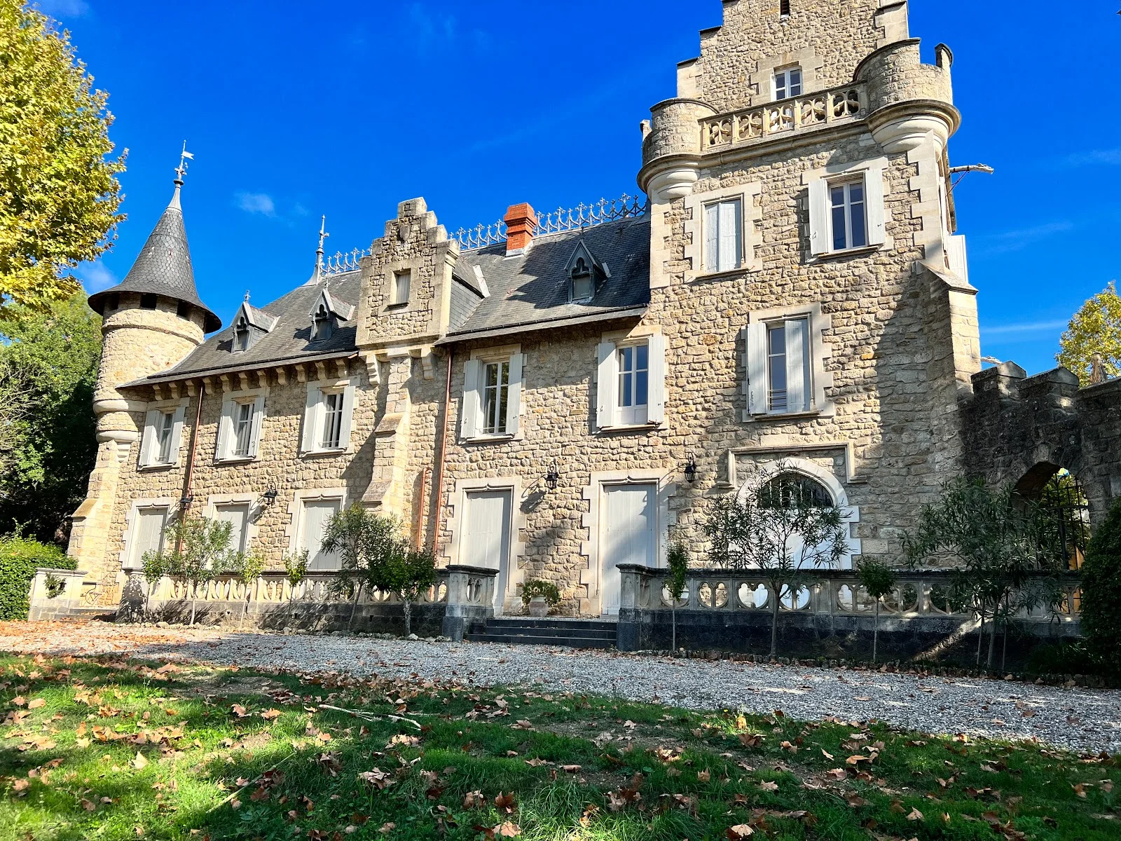 Vue latérale automnale du Château St Jean Hérault avec tourelle ronde et aile résidentielle en pierre