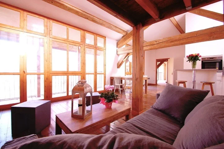 Loft lumineux avec baies vitrées et poutres apparentes dans l'hébergement du Château St Jean Hérault