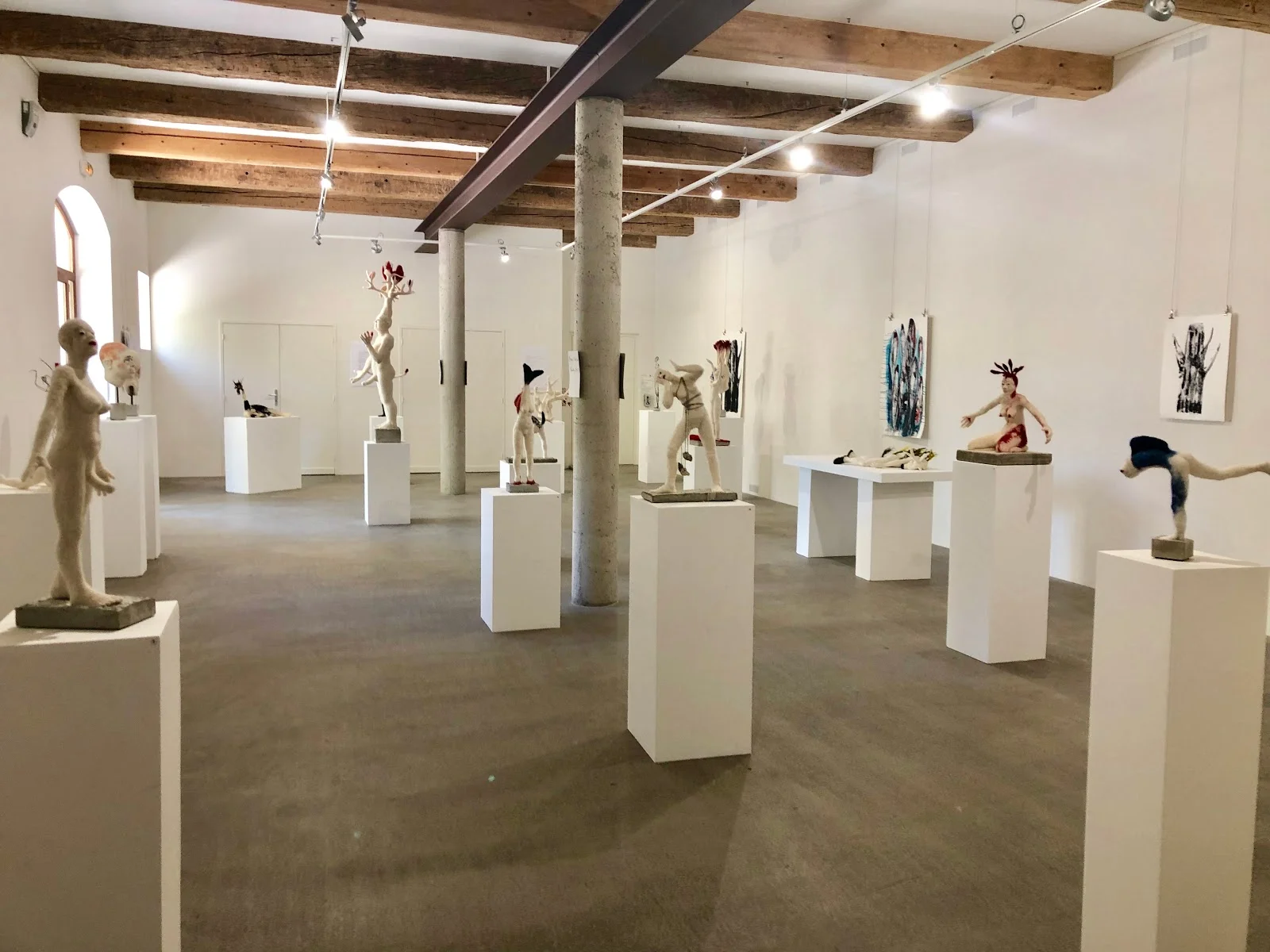 Salle d'exposition du Château St Jean Hérault avec poutres apparentes et sculptures pour réception de mariage
