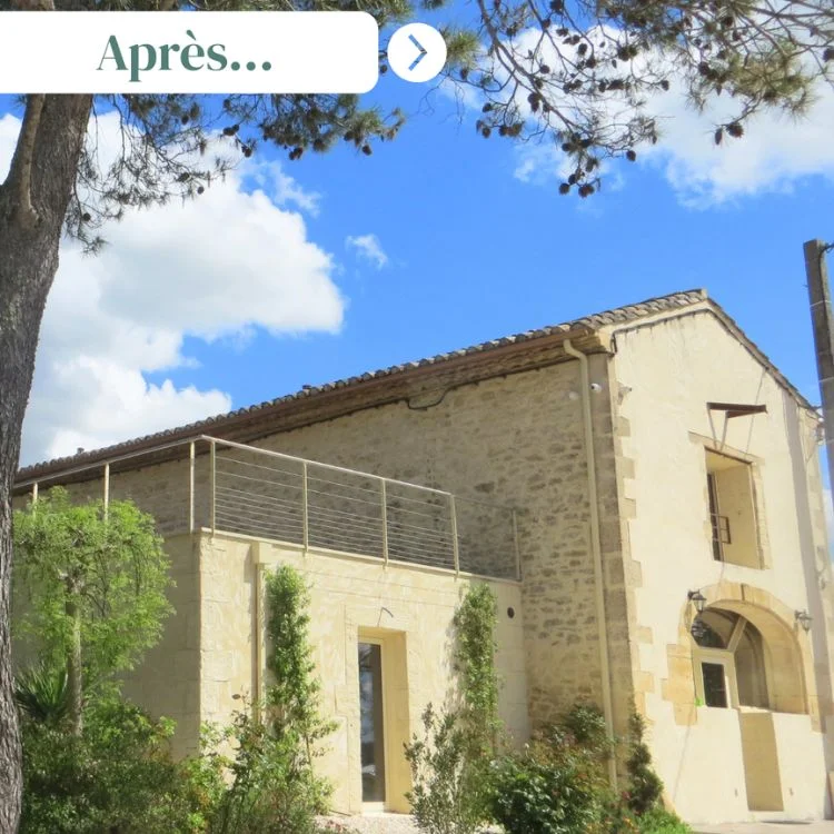 Façade rénovée du Domaine de Christin dans l'Hérault, bâtisse en pierre calcaire entourée de végétation méditerranéenne